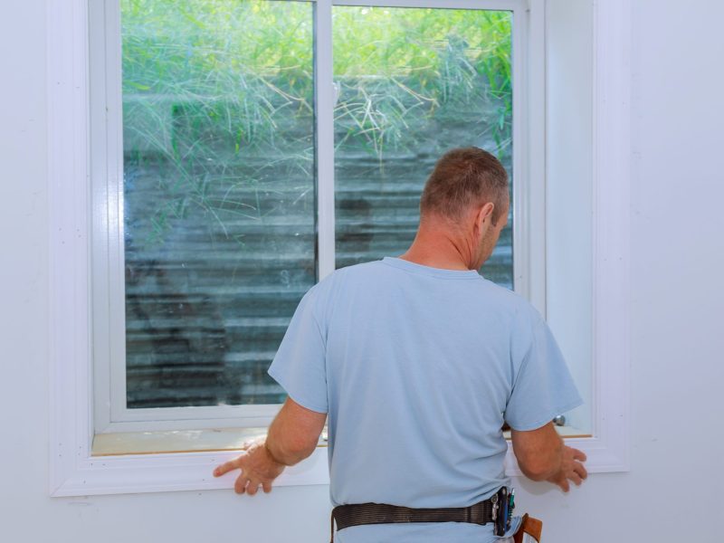 Worker installing trim around a window molding installed moldings materials